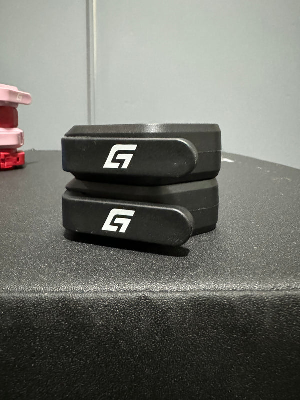 Pair of black magnetic barbell collars stacked on a bench